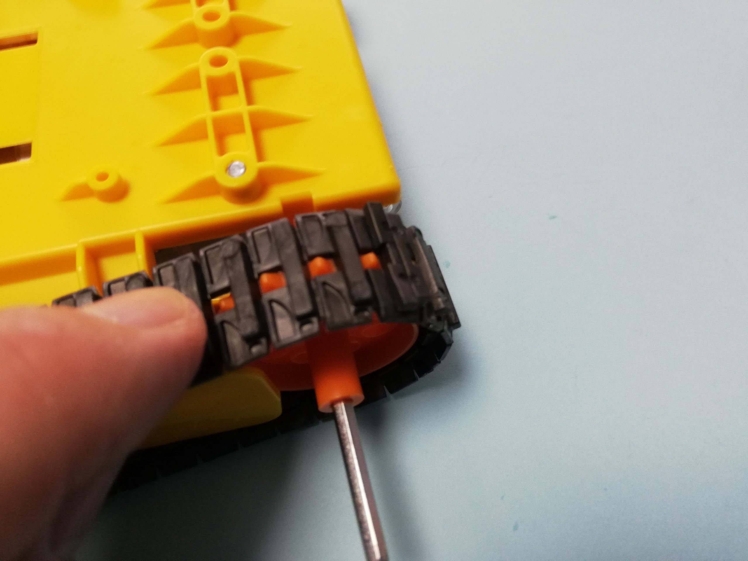 組立てたクローラー（無限軌道）を本体側に取り付けます。モーターで回る車輪（起動輪）の突起をクローラー（無限軌道）の穴に入れます。